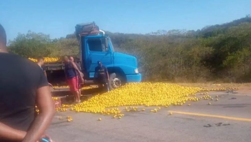 Caminhão tomba, bate em ônibus e espalha carga de laranja na MG-050