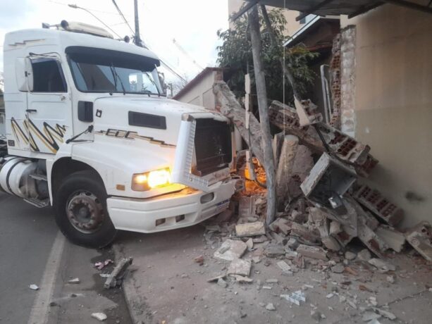 Motorista bate caminhão, destrói muro e telhado de duas casas e foge
