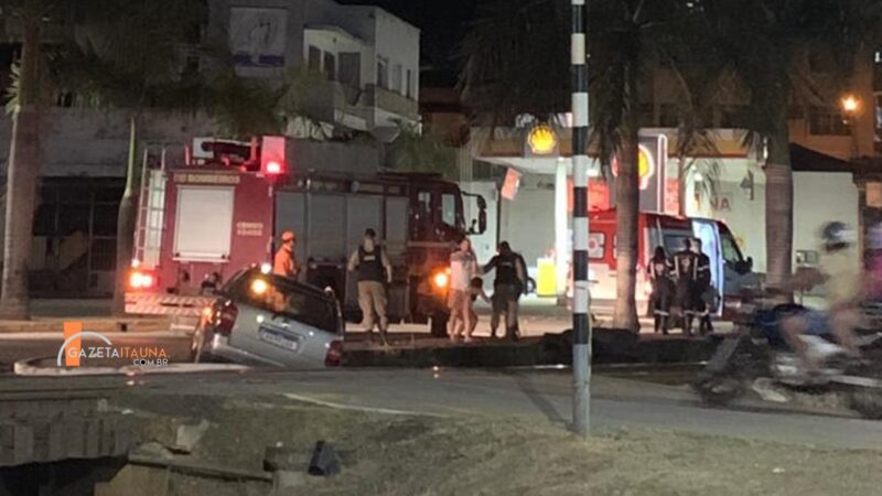 Carro cai em vala entre passeio e linha férrea com duas pessoas