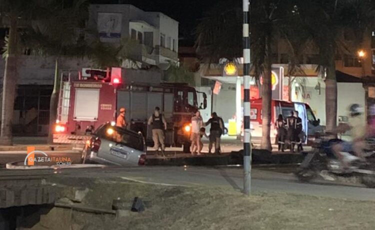 Carro cai em vala entre passeio e linha férrea com duas pessoas